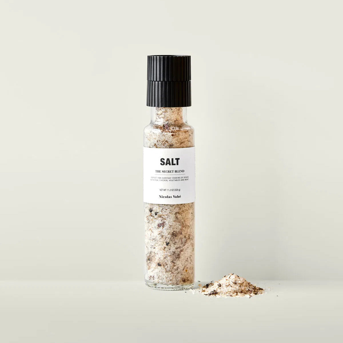 Bottle of salt with a black cap on a light background
