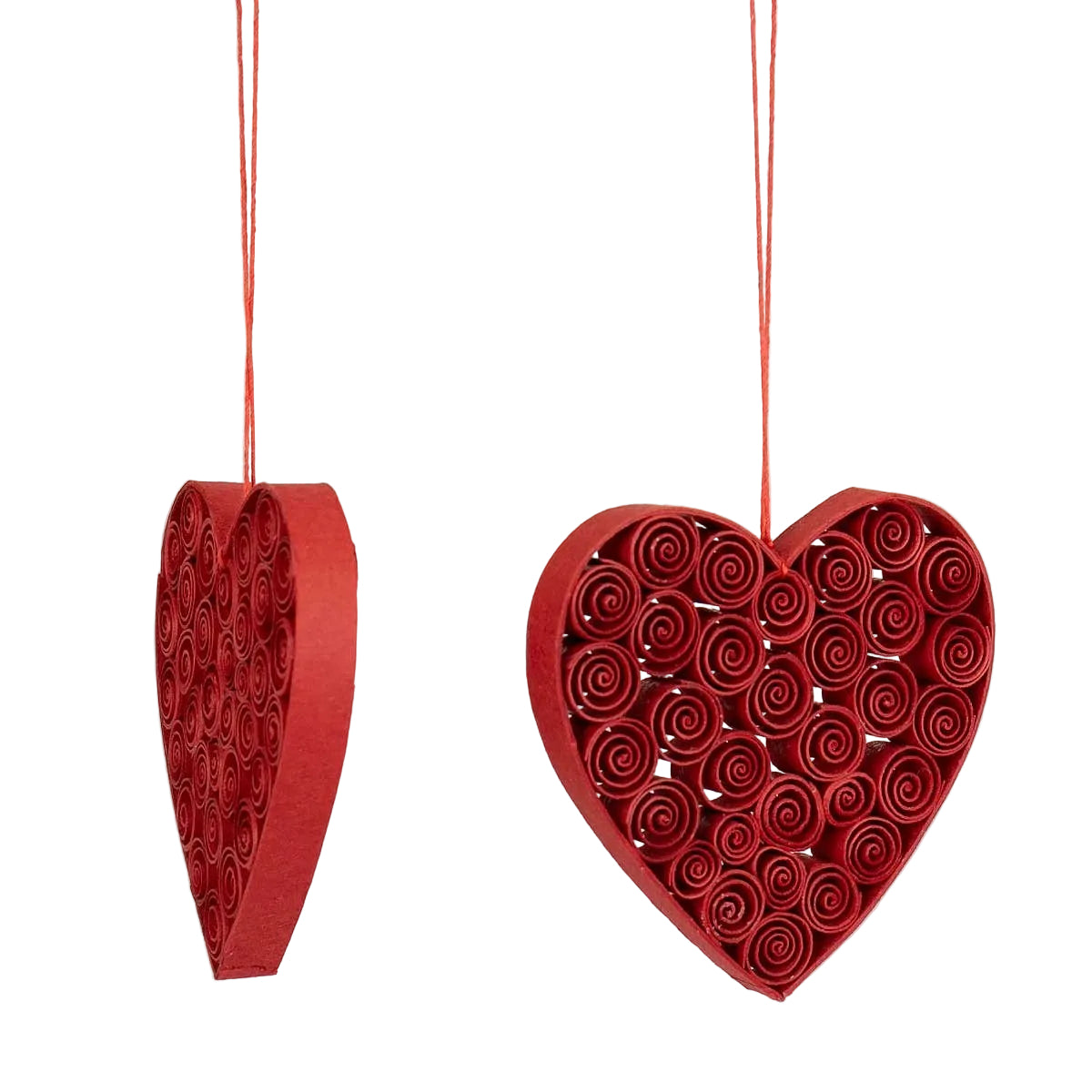 The Quilled Heart Christmas Ornaments, Set of 2 by A World of Craft feature handmade red hearts crafted from rolled paper strips—one showing its side, the other a spiral pattern—hanging from red strings and making eco-friendly holiday decorations.