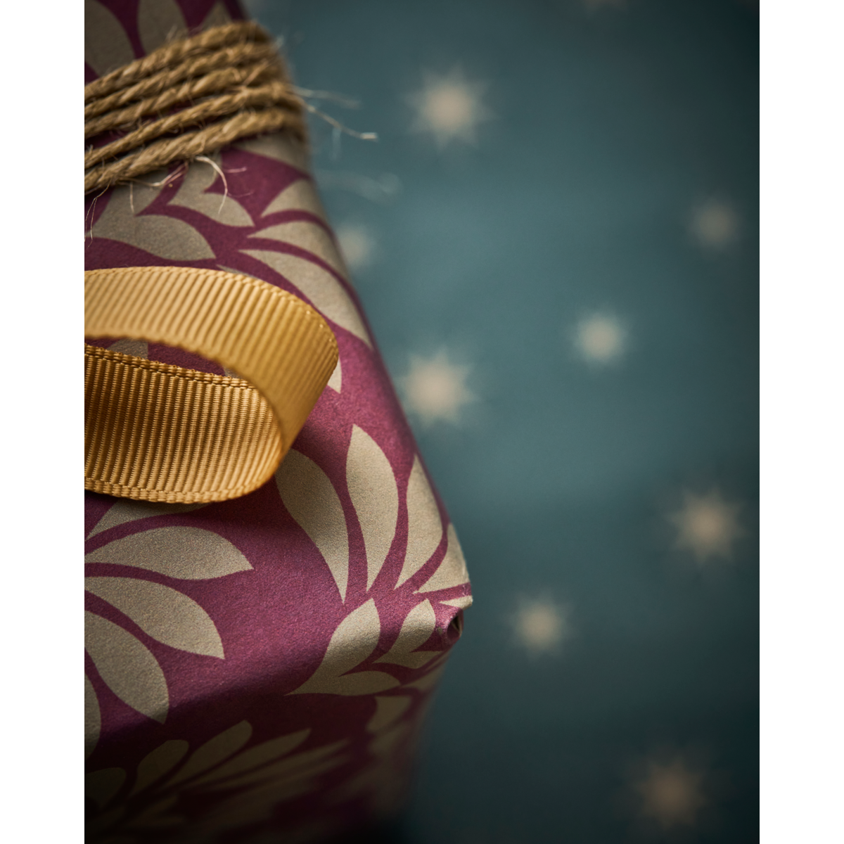 A wrapped gift features House Doctor's double-sided red and green gift wrapping paper with gold accents, displayed against a blue background with white stars.