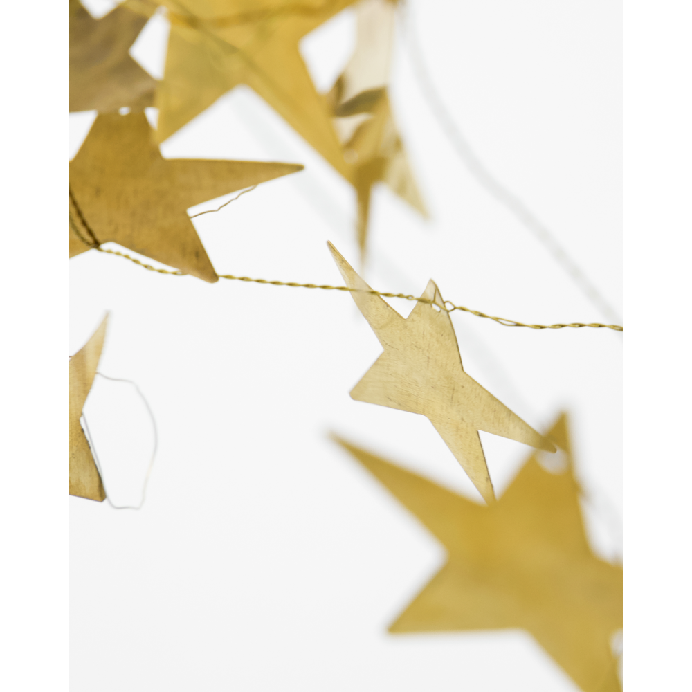A House Doctor Garland Stars in Antique Brass, 1.5 m featuring a garland of handcrafted metallic brass stars strung on a thin gold wire.