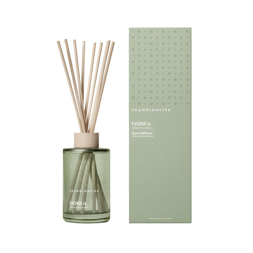 The Skandinavisk Scent Diffuser Fjord 200ml features wooden reeds in a green glass bottle with matching packaging—a vegan Scandinavian room fragrance that adds style to any space.