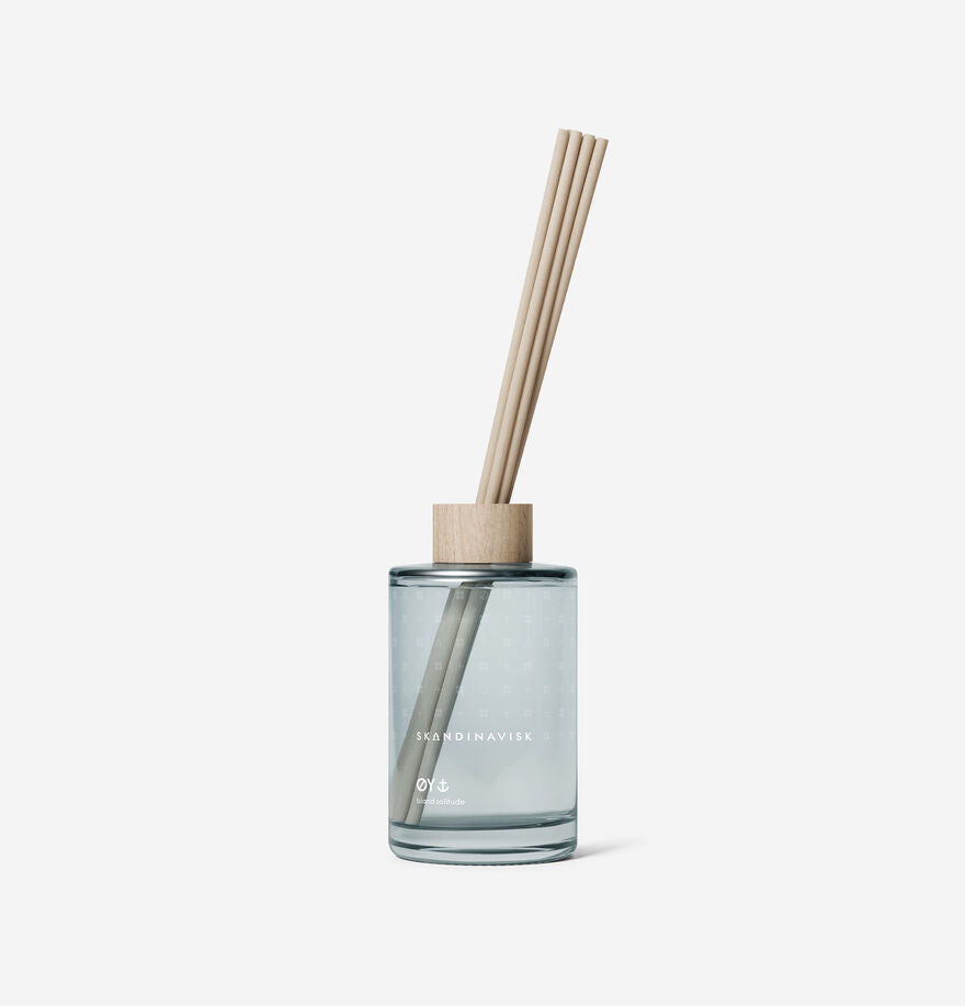 The Skandinavisk Scent Diffuser Øy, 200ml, features clear glass, light wooden reeds, and a wooden cap to infuse your space with fresh Scandinavian fragrance.