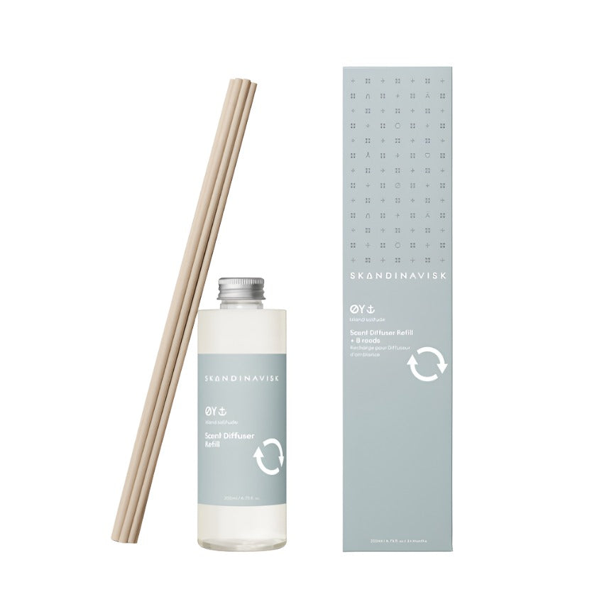A Skandinavisk Scent Diffuser Refill Øy, 200 ml set featuring a clear bottle of Scandinavian fragrance liquid, light-colored reed sticks, and a tall, pale blue box with product details and a white recycling symbol—ideal for stylishly refreshing your room fragrance.