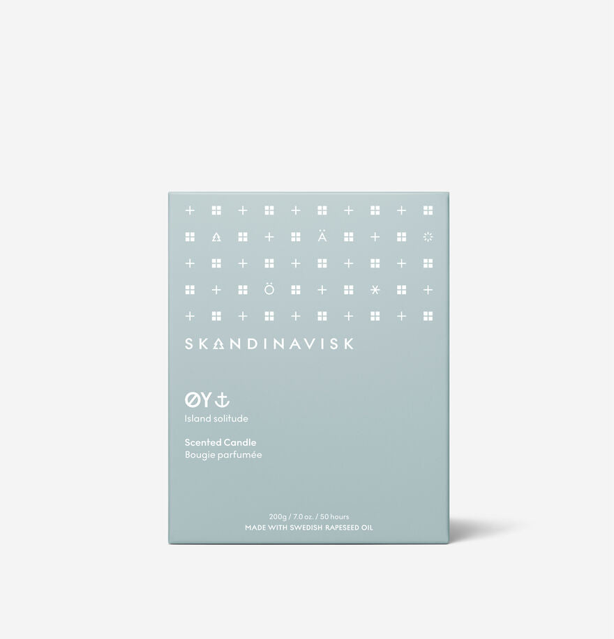 The Skandinavisk Scented Candle Oy 50h, 200g comes in a light blue box with simple white geometric symbols, crafted from Swedish rapeseed wax and labeled "ØY Island solitude.