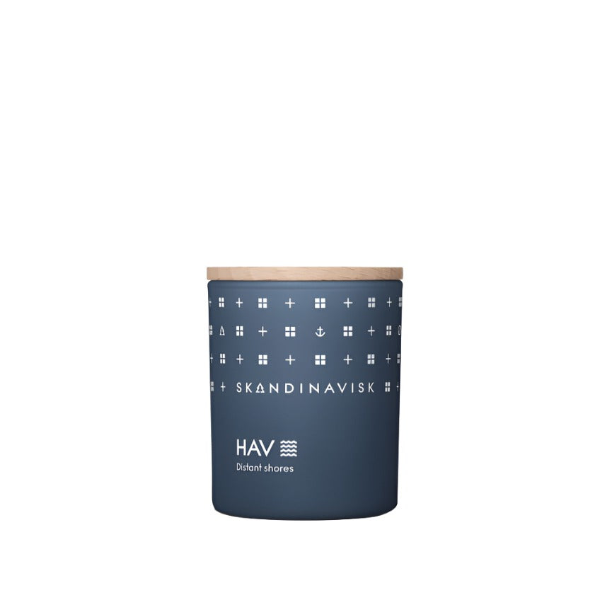 The Skandinavisk Mini Scented Candle Hav 20h, 65g is a blue cylindrical candle with a wooden lid, white geometric patterns, and "SKANDINAVISK HAV Distant shores" text, inspired by the Scandinavian sea and made with Swedish rapeseed wax.