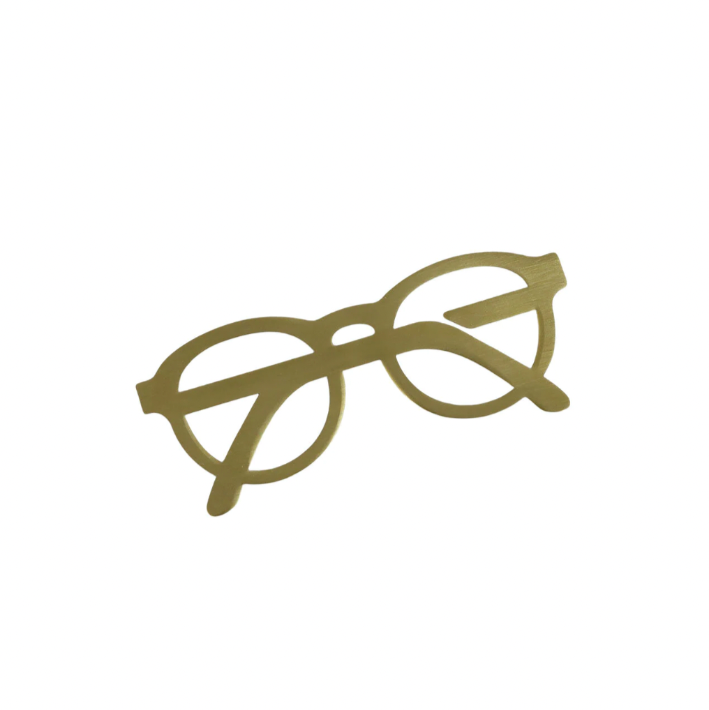 The Brass Book Marker by Strömshaga is a flat, gold-colored metal cutout shaped like eyeglasses, elegantly displayed against a white background.