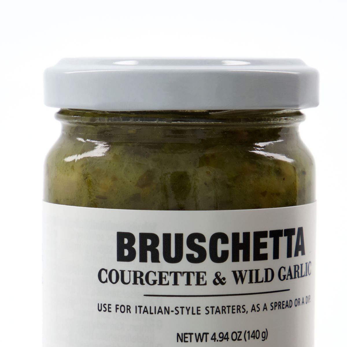 A jar of Nicolas Vahé Bruschetta, Courgette & Wild Garlic with a light gray lid—ideal as a spread or dip for Italian-style starters. The label features courgette and wild garlic blend; net weight: 4.94 oz (140 g).