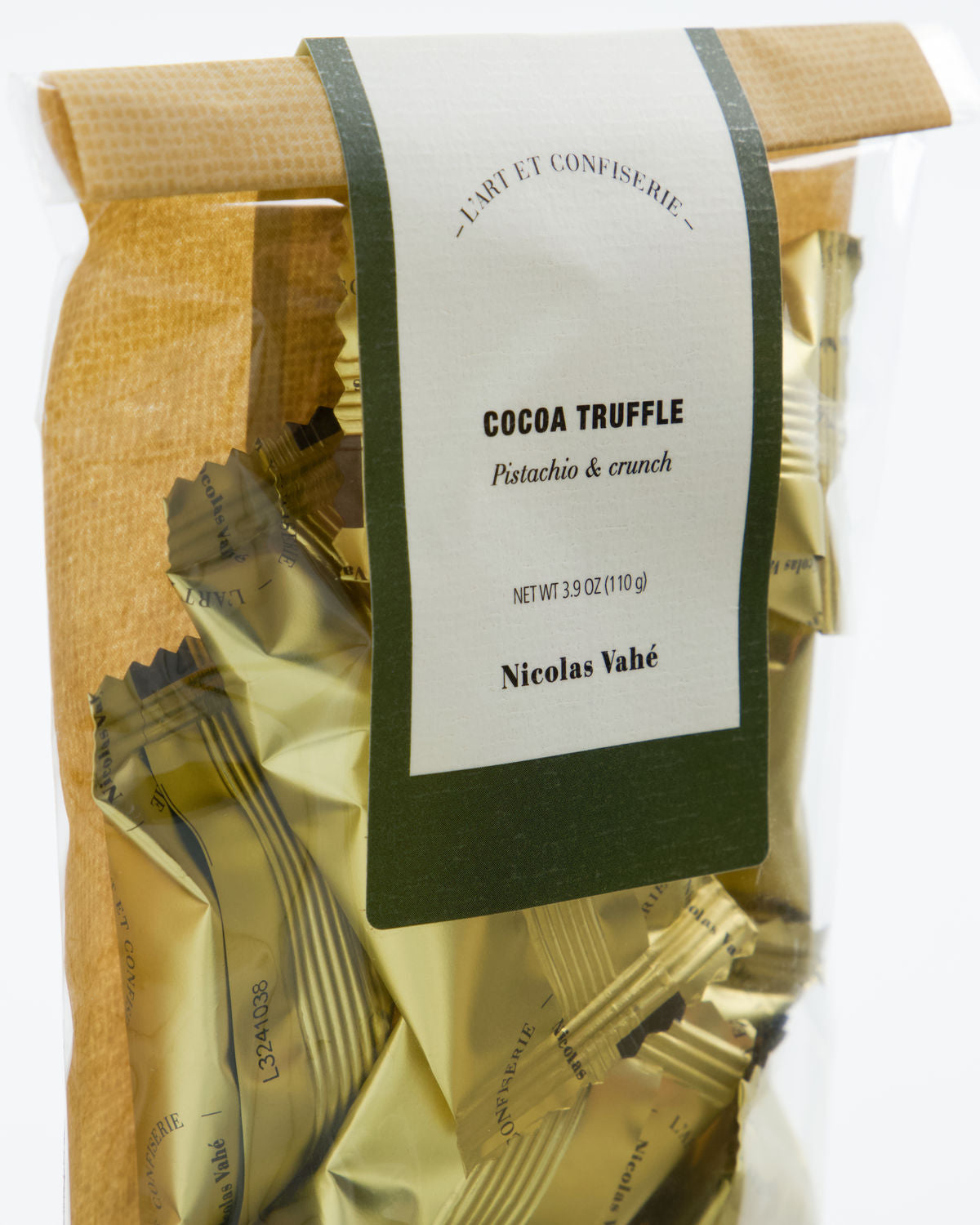 A clear bag of Nicolas Vahé Chocolate Truffles, Pistachio & Crunch, individually wrapped in gold foil with a green and white label.