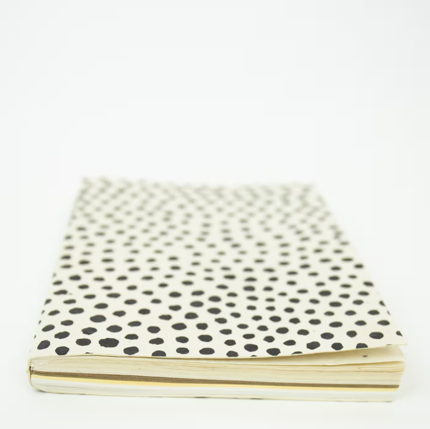 The A World of Craft Dotted Notebook, White, A5, features eco-friendly handmade lokta paper and a cream cover with irregular black polka dots, highlighting its artisanal charm against a white background.