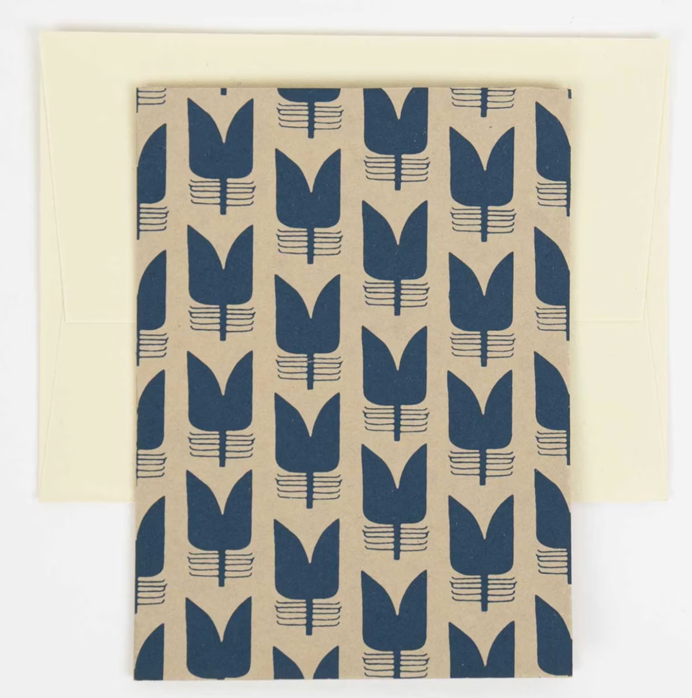 The Blue Tulip Handmade Greeting Card by A World of Craft features dark blue tulip patterns on brown handmade paper and comes with a cream envelope, crafted with care for a unique artisanal touch.