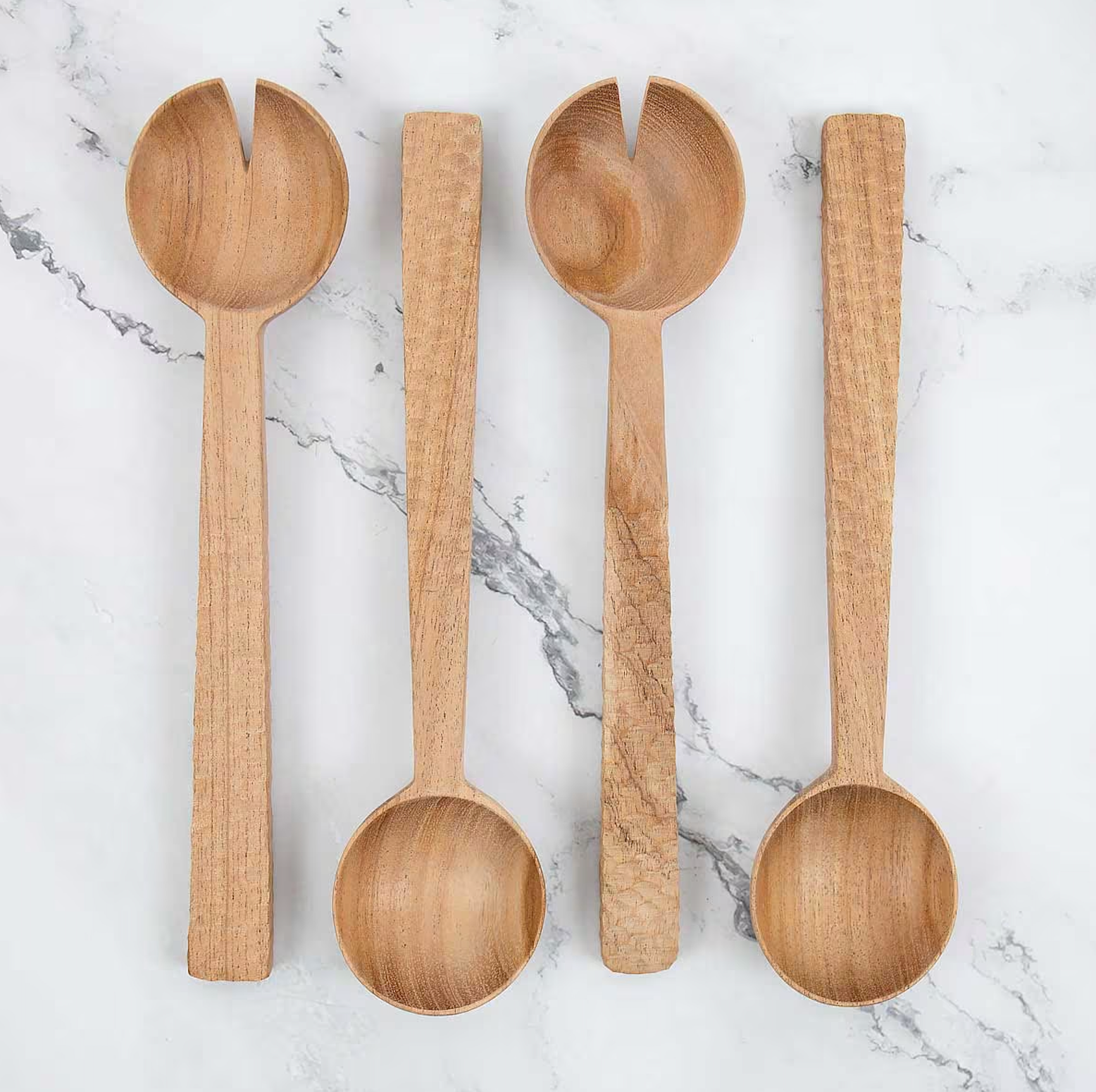 Four A World of Craft Handmade Neem Salad Servers are arranged side by side on marble—two are solid spoons, and two are slotted servers with a single notch in the bowl.