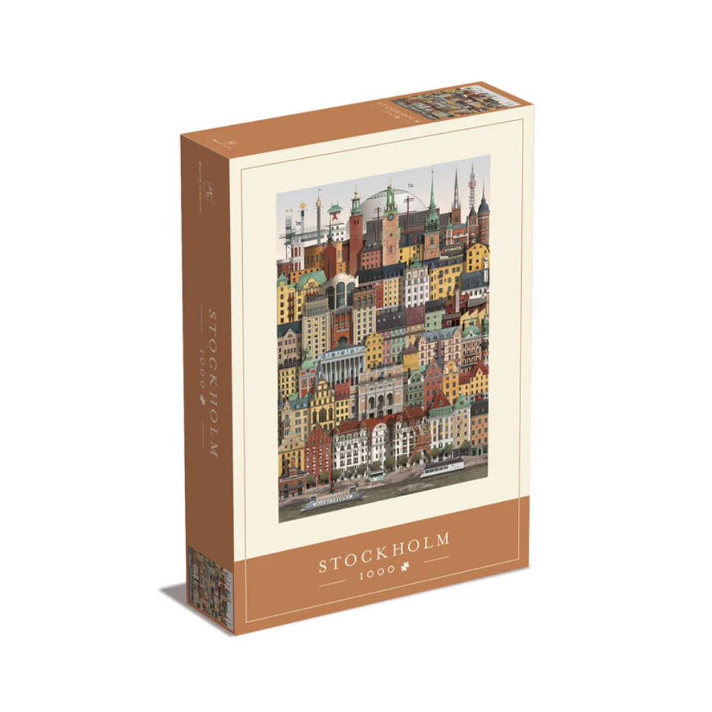 The Martin Schwartz Stockholm City Puzzle, 1000 Pieces, comes in a beige, vertical box with “Stockholm” and the piece count on it, featuring an illustration of colorful, detailed city buildings.