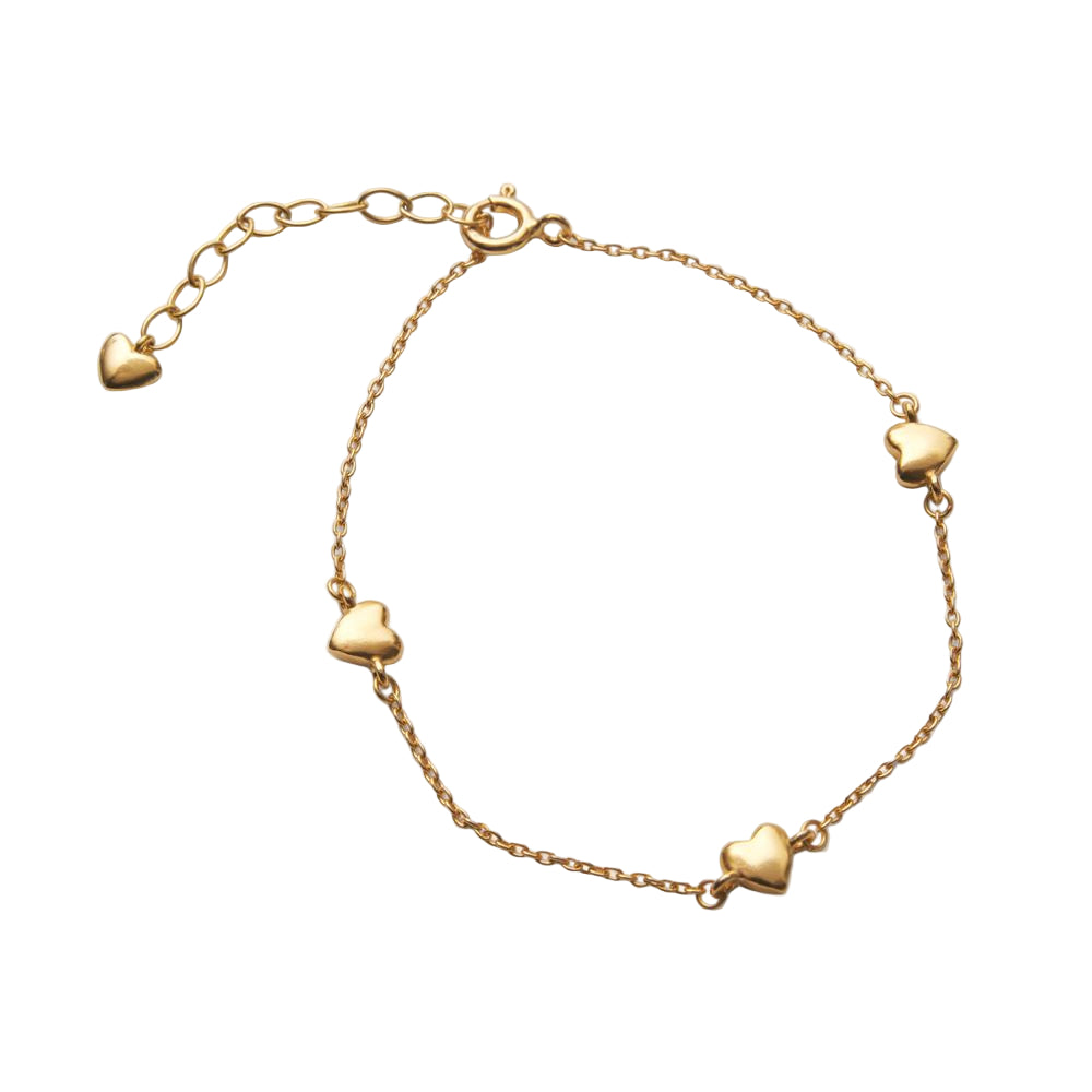 The Adore Bracelet in Gold by Pernille Corydon is a minimalistic gold bracelet with four evenly spaced heart-shaped charms, an adjustable clasp, and an extra heart charm at the extender's end.