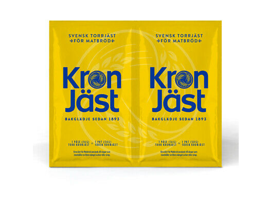 Two yellow sachets of Deli Kronjast Dry Yeast 2x14g (equals 100g fresh yeast) side by side, with blue text and instructions on the packs—perfect baking yeast for home use.