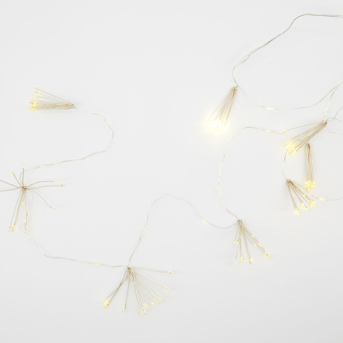 The House Doctor String Lights, Glow LED, Silver Finish 1.5m, featuring small bundled LED clusters, are arranged on a plain white surface.