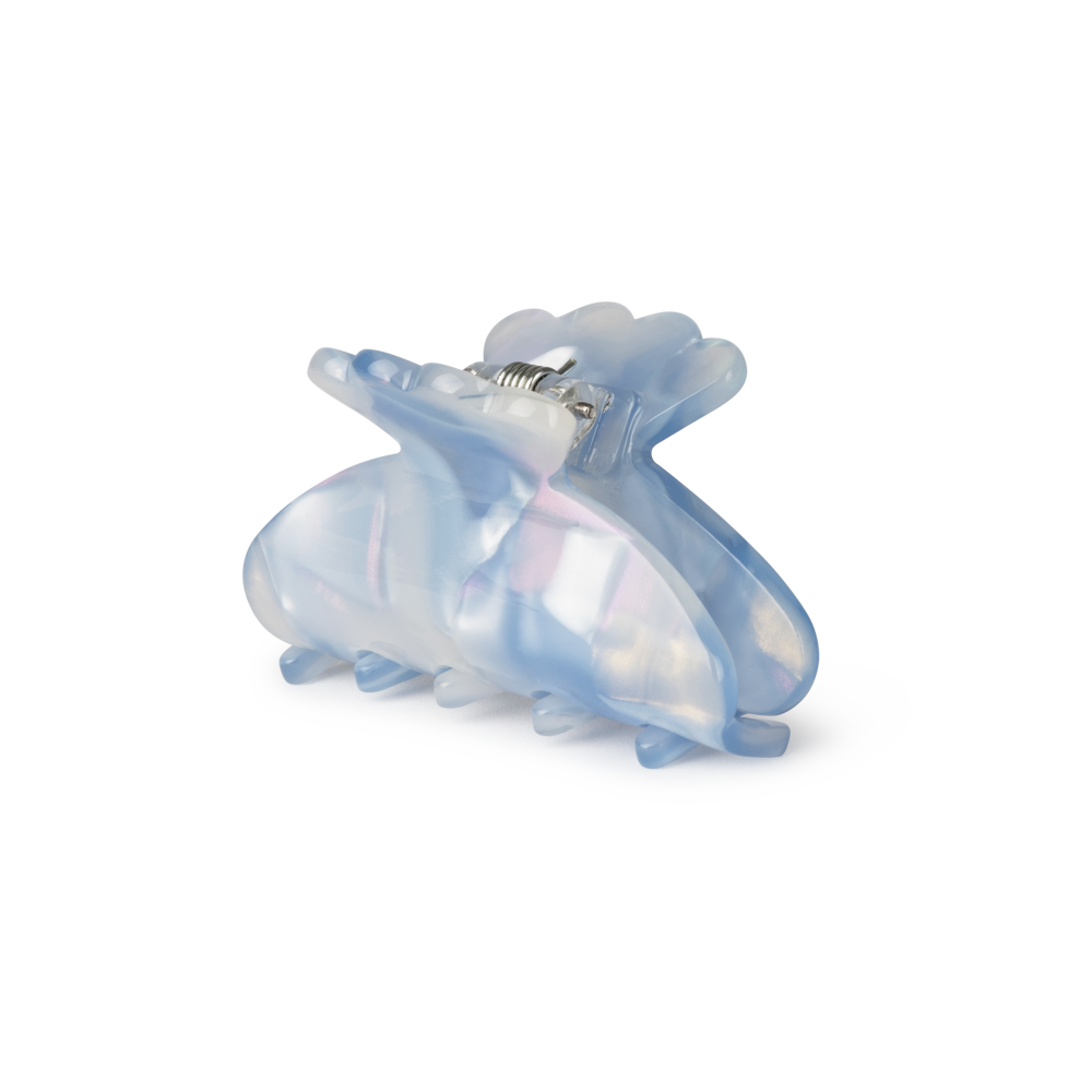 The Sui Ava Helle Flopsy Mini Hair Claw Clip in Blue features translucent light blue and pearly white acetate with a shiny finish, shown closed against a plain white background.