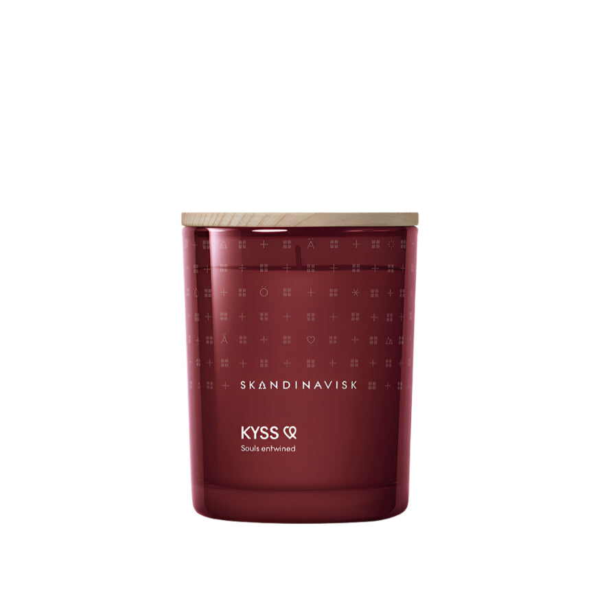 The Skandinavisk Scented Candle Kyss, 200g, is crafted from Swedish rapeseed wax with a wooden lid. Featuring blackberries and rose fragrance, it comes in a burgundy glass with minimal design and white SKANDINAVISK and KYSS Souls entwined text.
