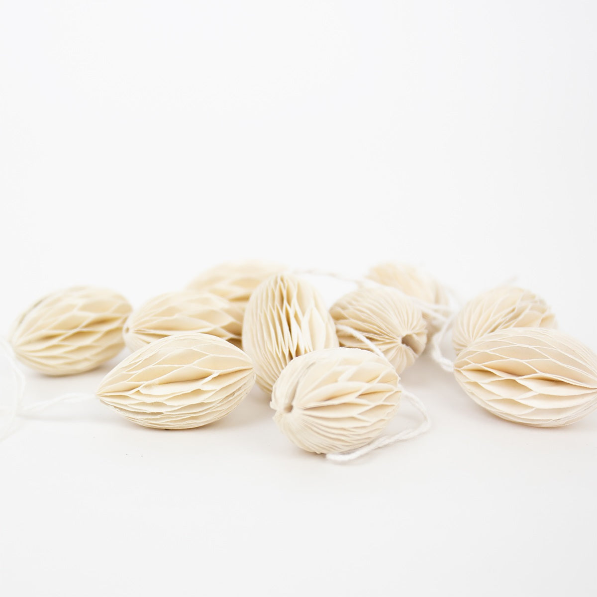 The Honeycomb Easter Egg Ornaments by A World of Craft are a set of 10 cream-colored paper eggs with string, ideal for decorating your home or hanging on a Swedish Easter tree.