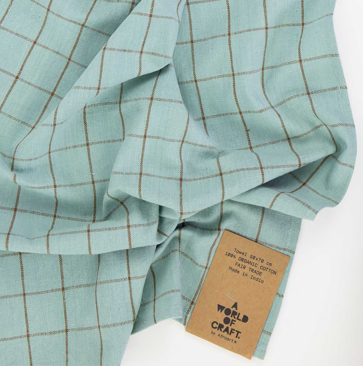 The Eco Grid Tea Towel in turquoise and brown by A World of Craft features a hand-woven look, subtle crumples, a label, and is made from organic cotton for fair trade appeal.