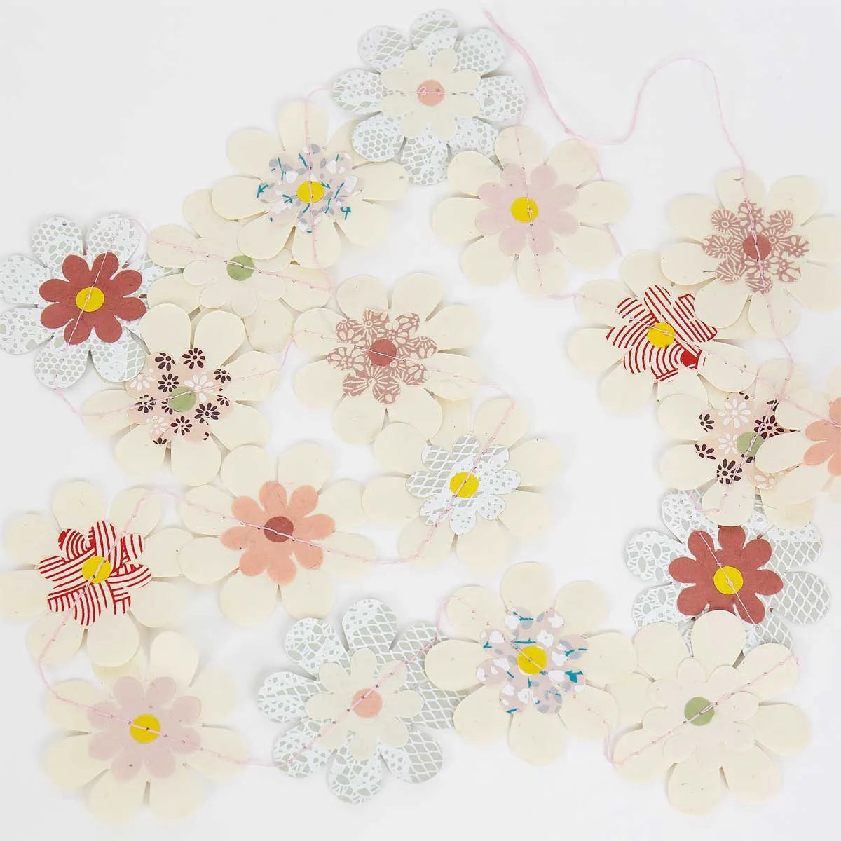 The Cherry Blossom Paper Garland by A World of Craft features pastel lokta handmade paper flowers in assorted patterns, artfully arranged against a light background.