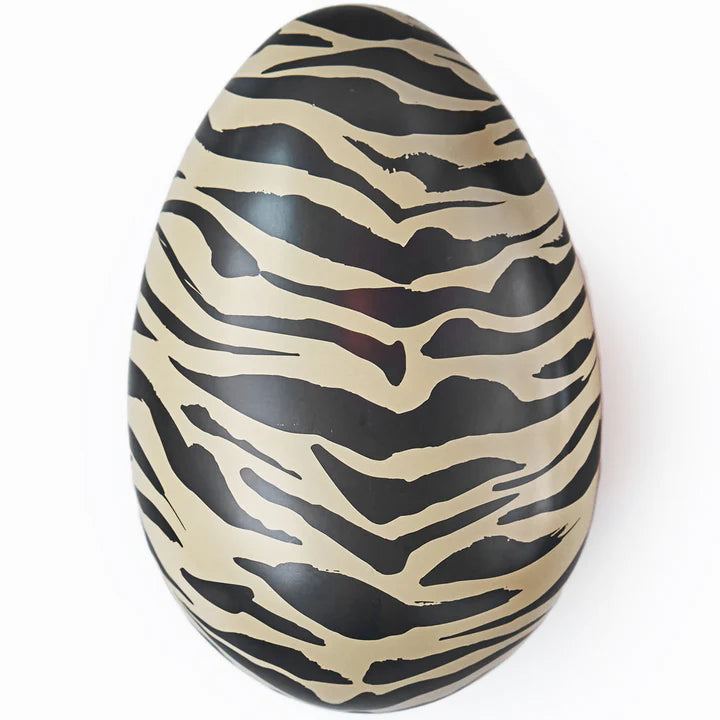 This Tiger Reusable Easter Egg by Gåva Gifting features a black and beige stripe pattern in the style of a Swedish Påskägg, crafted from tin and shown against a white background.