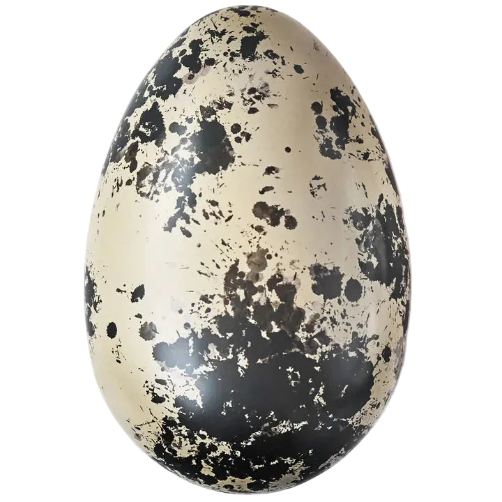 A beige and black speckled reusable Easter egg inspired by quail eggs, intended for decoration or as a container for treats.