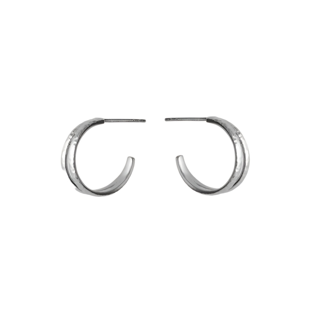 The Poetry Hoops in Silver by Pernille Corydon feature a slightly hammered texture and half hoop design, shown against a plain white background.