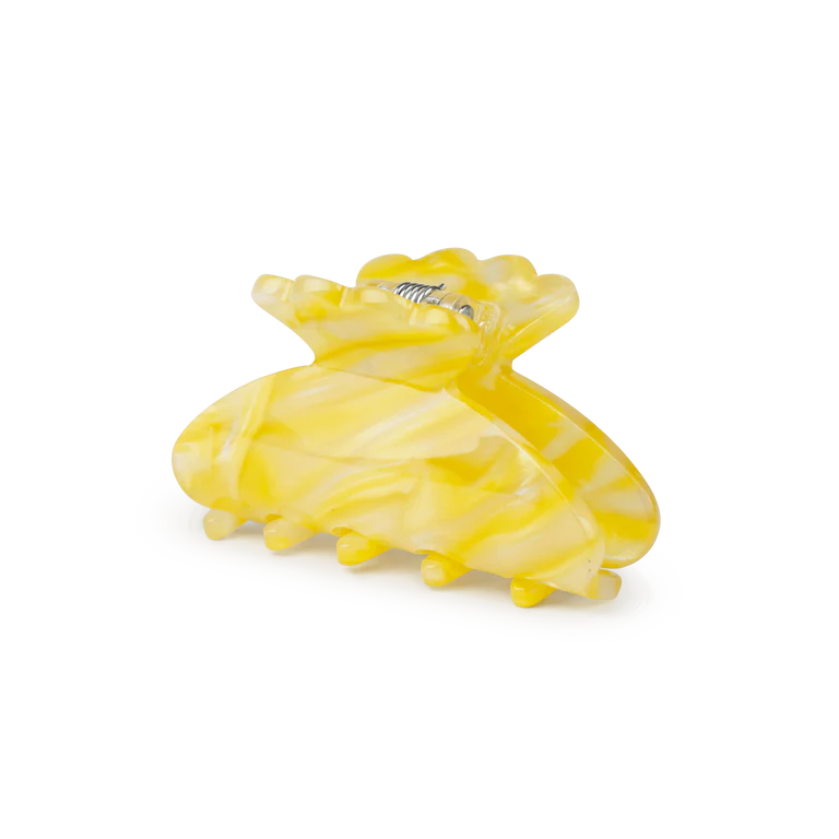The Sui Ava Helle Fresh Mini Hair Claw Clip in Yellow features a marbled plastic design, metal spring, rounded teeth, and curved shape—ideal for securing fine hair with style.