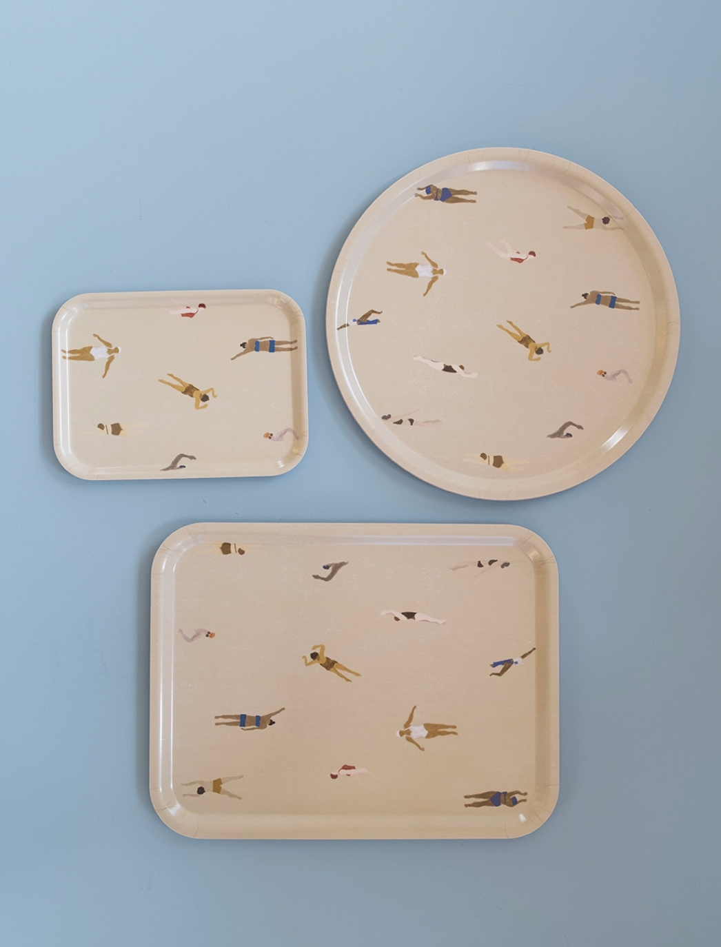 Three Swimmers trays in laminated birch wood, featuring a playful design and perfect for kitchen use.