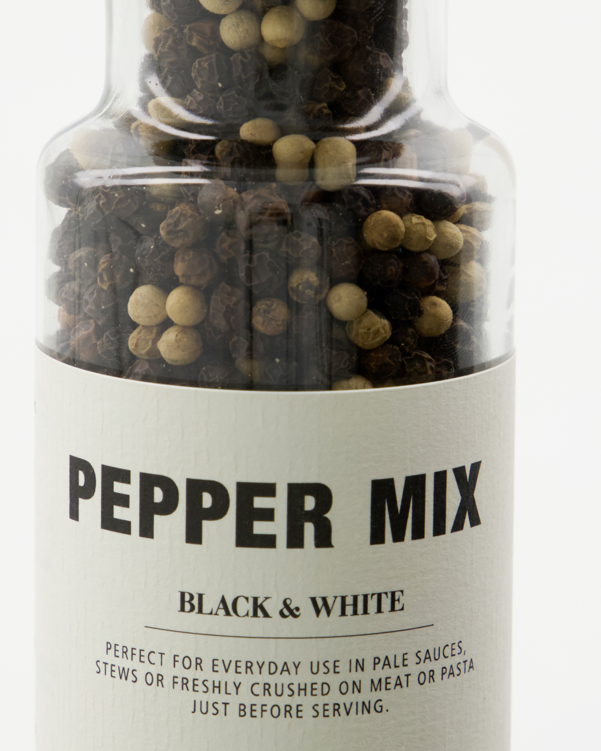 A clear glass bottle labeled "Pepper Mix, Black & White" by Nicolas Vahé, filled with black and white peppercorns—ideal for seasoning sauces, stews, meats, or pasta.