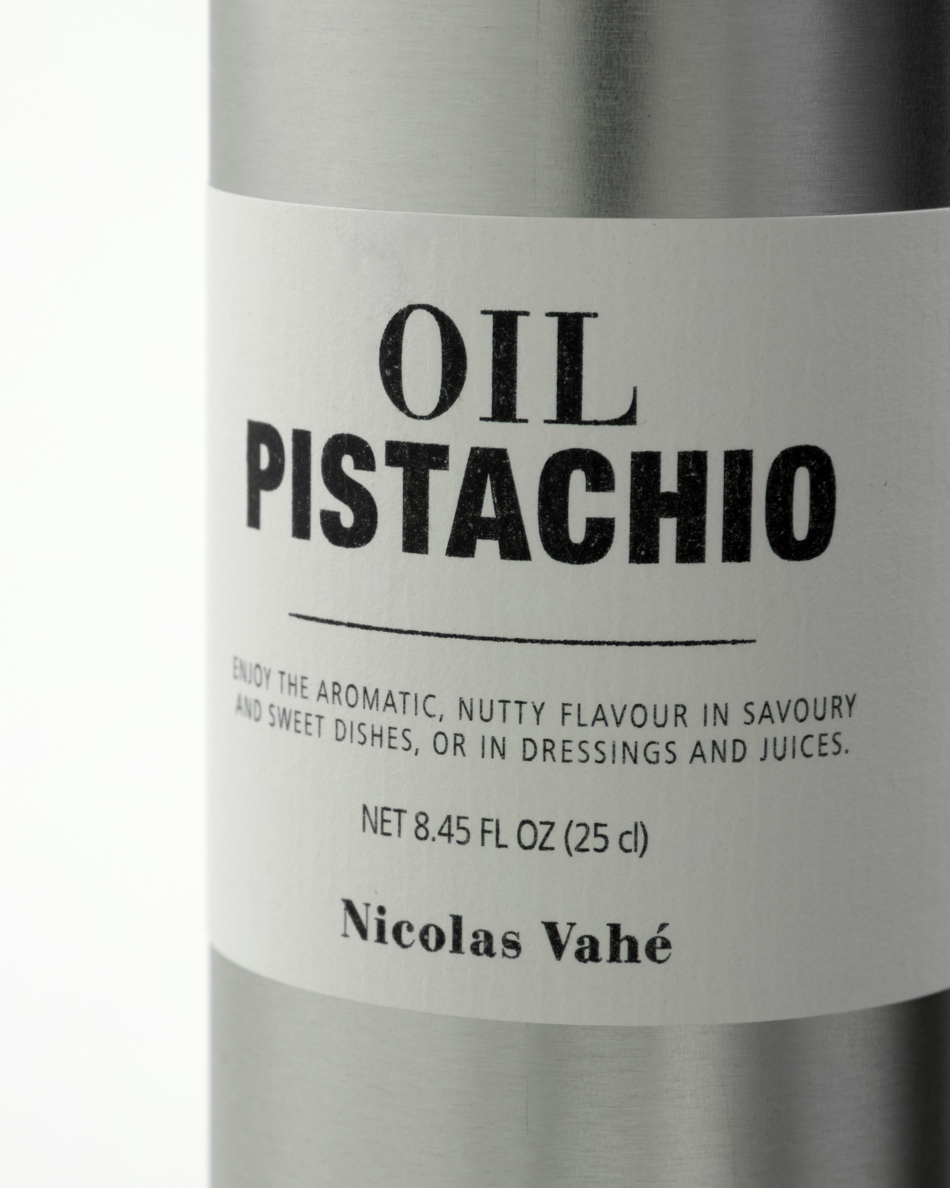 A close-up of a metal bottle labeled Pistachio Oil by Nicolas Vahé, displaying its product details and a description highlighting its aromatic, nutty flavour—ideal for cooking and enhancing the delicate richness of both sweet and savory dishes with pistachio oil.
