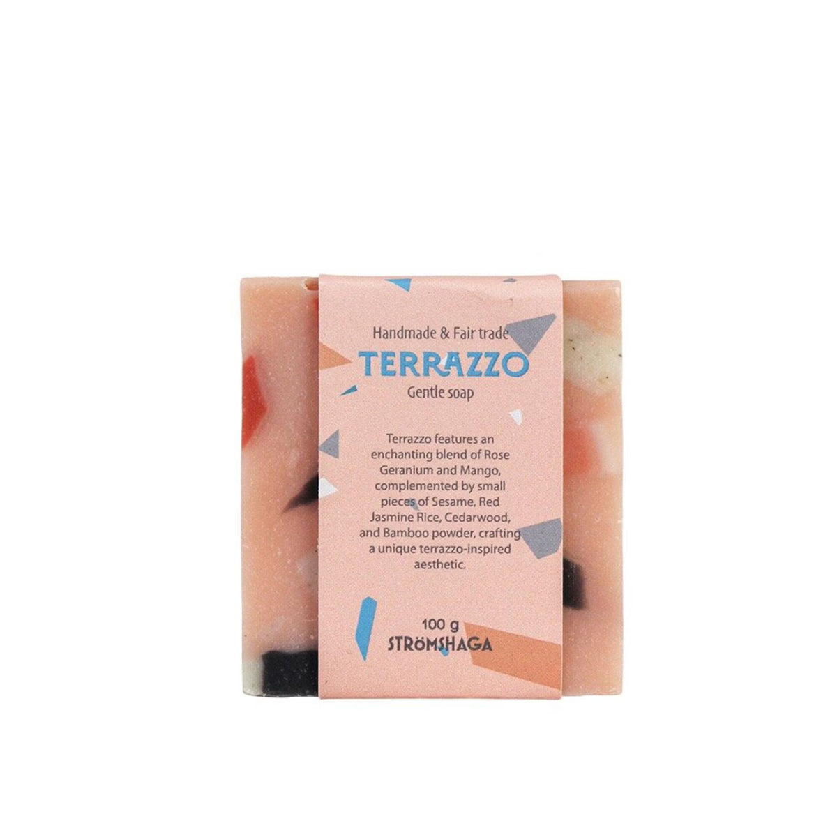 A handcrafted vegan soap bar by Strömshaga, labeled “Soap Bar, Terrazzo, Handmade & Fairtrade,” comes wrapped in pink and highlights its fair trade and natural ingredients—including rose geranium and mango. Colorful confetti-like pieces visible inside the bar provide a gentle exfoliating texture.