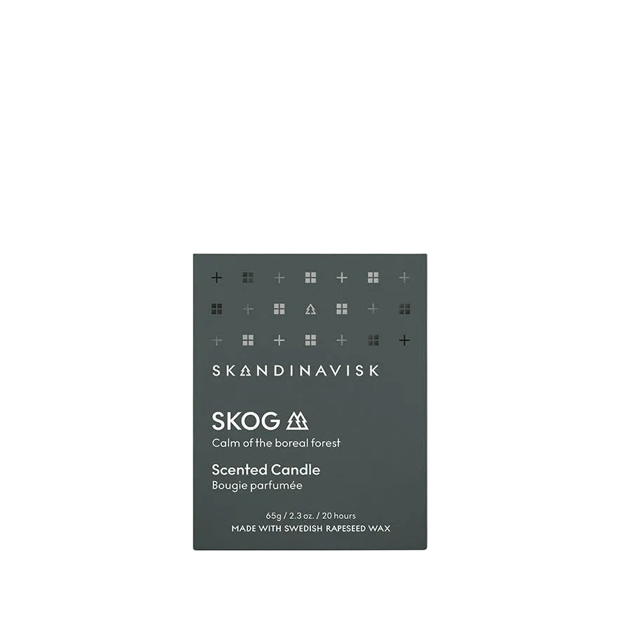 A dark green box of Skandinavisk Mini Scented Candle Skog, 65g, featuring minimalist white icons and text. This sustainable Swedish rapeseed wax candle evokes the calm of northern boreal forests.