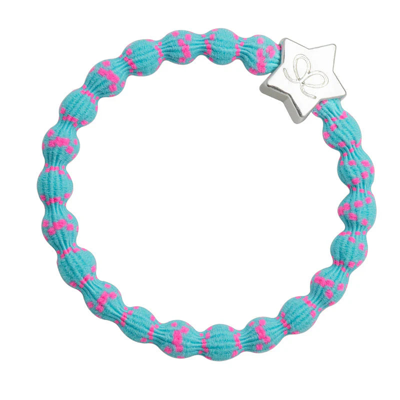 ByEloise’s Bangle Band Silver Star in bubblegum pink on blue features a blue, snag-free elastic hairband with pink dots, adorned with a silver star-shaped charm with a delicate bow design, shown against a white background.