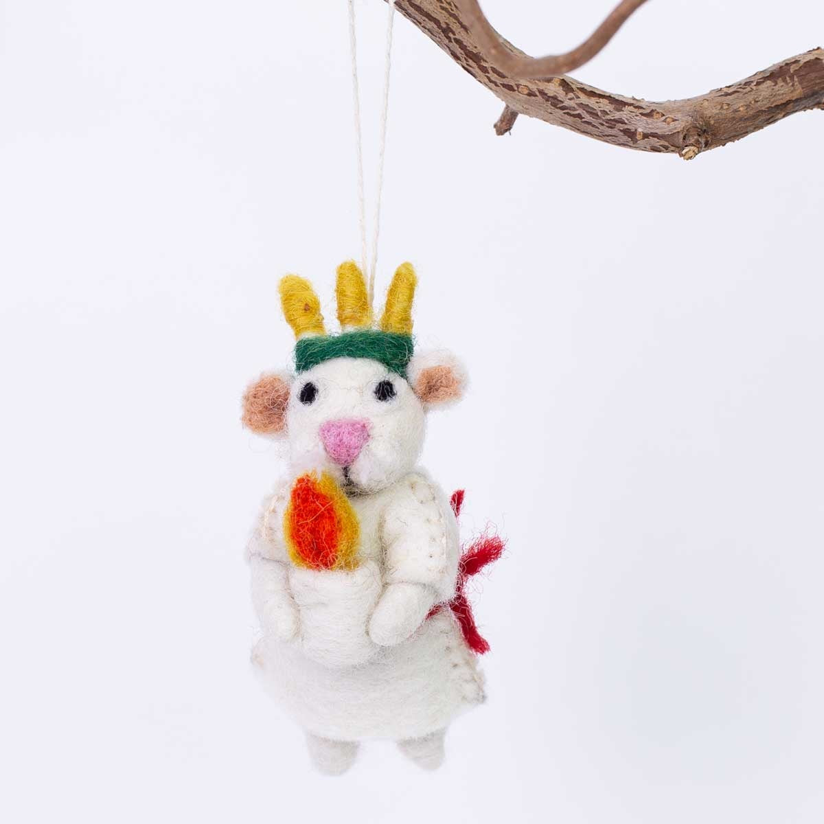 Expertly handcrafted in wool by A World of Craft, the Lucia Christmas Ornament features a felt mouse adorned with a crown and candle, hanging gracefully from a tree branch against a simple white backdrop—a delightful tribute to the Swedish Santa Lucia tradition.