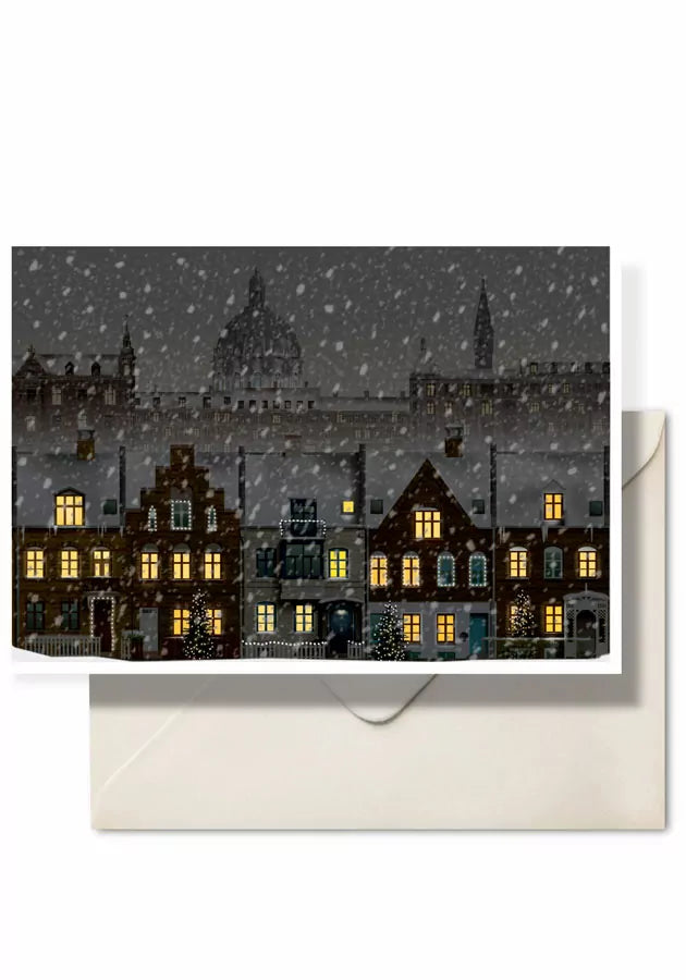 The Martin Schwartz “Card, Christmas in Copenhagen, Kartoffelrækkerne” features a charming winter scene with snow falling on a row of illuminated houses beneath the city’s historic domes, beautifully capturing the spirit of Denmark’s capital. Presented in an elegant A5 format with a matching envelope included.