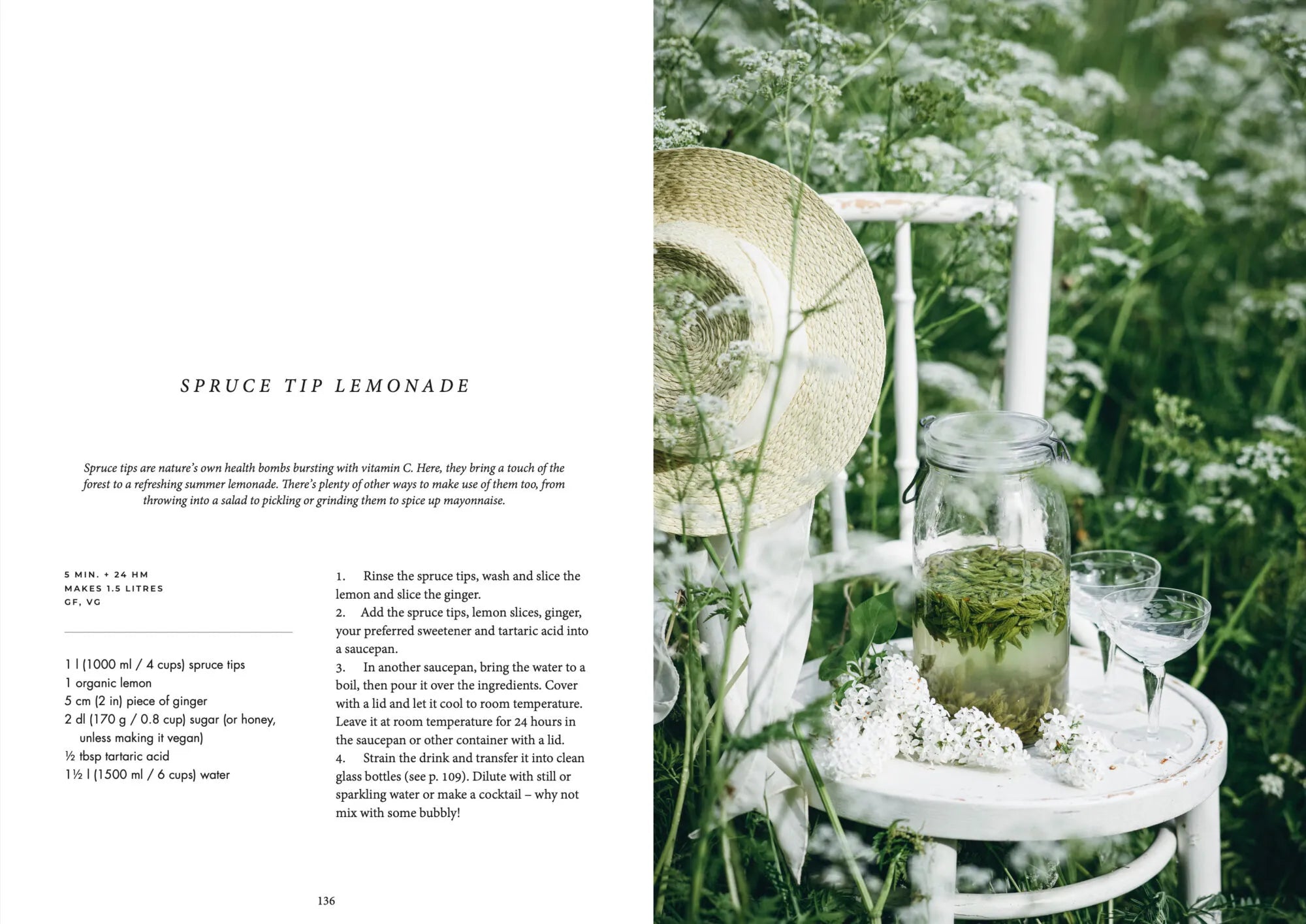 A glass and a jar of spruce tip lemonade sit on a white chair in a wildflower field, with recipe text from the Nordic Summer Cookbook by Cozy Publishing shown on the left; a straw hat rests on the chair’s back.
