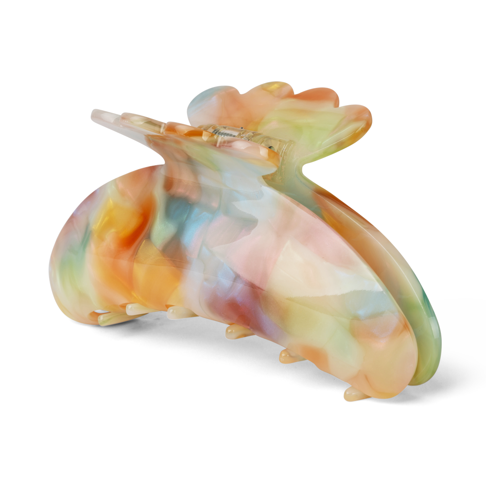 The Sui Ava Helle Dreamy Big Hair Claw Clip in Dreamy Vibes features a glossy, marbled finish in pastel orange, yellow, blue, pink, and green. Its curved butterfly shape is designed for long hair and provides a strong grip.