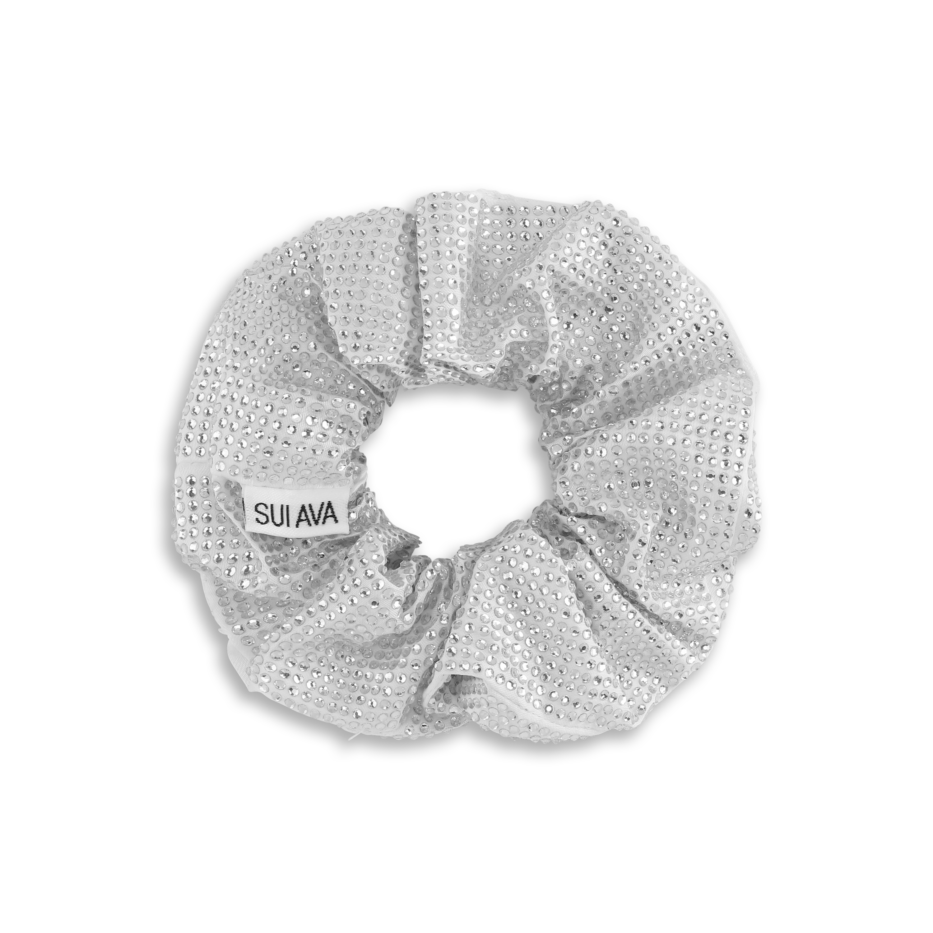 The Kelly Crystal Scrunchie by Sui Ava is a silver hair accessory embellished with small rhinestones and a white Sui Ava label, shown on a black background.