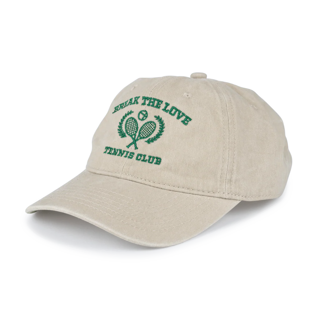 The Sui Ava Everyday Cap, Tennis Break the Love in Beige, is crafted from 100% cotton and showcases green BREAK THE LOVE TENNIS CLUB text with crossed tennis rackets and laurel leaves embroidery.