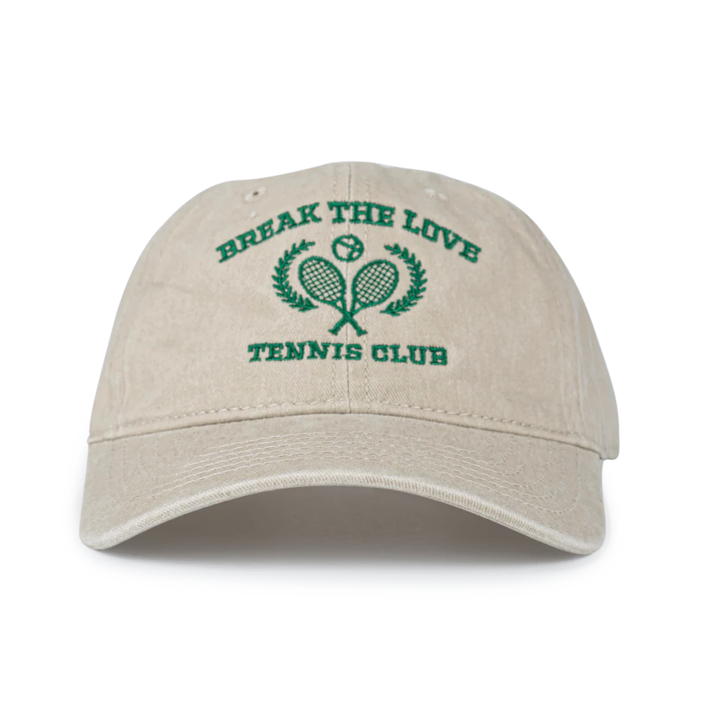 The Sui Ava Everyday Cap, Tennis Break the Love in Beige is a 100% cotton baseball cap with green embroidered BREAK THE LOVE TENNIS CLUB text and crossed racket logo—perfect for tennis enthusiasts.
