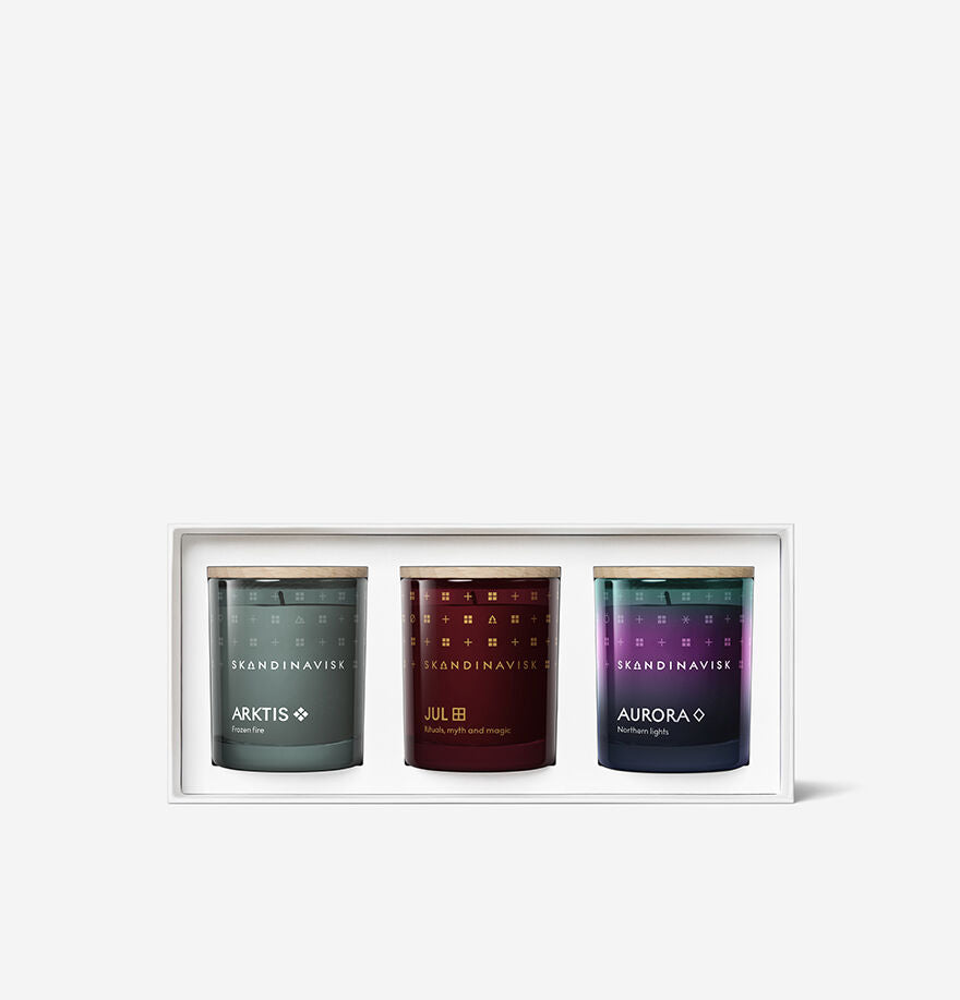 The Skandinavisk Scented Candle Winter Solstice Mini Giftset features three mini candles—Arktis, Jul, and Aurora—each made with Swedish rapeseed wax in glass jars with wooden lids.