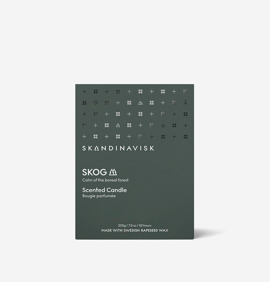 A dark green Skandinavisk Scented Candle Skog (200g, 50h), inspired by the calm of the boreal forest and made with Swedish rapeseed wax. Refill options available.