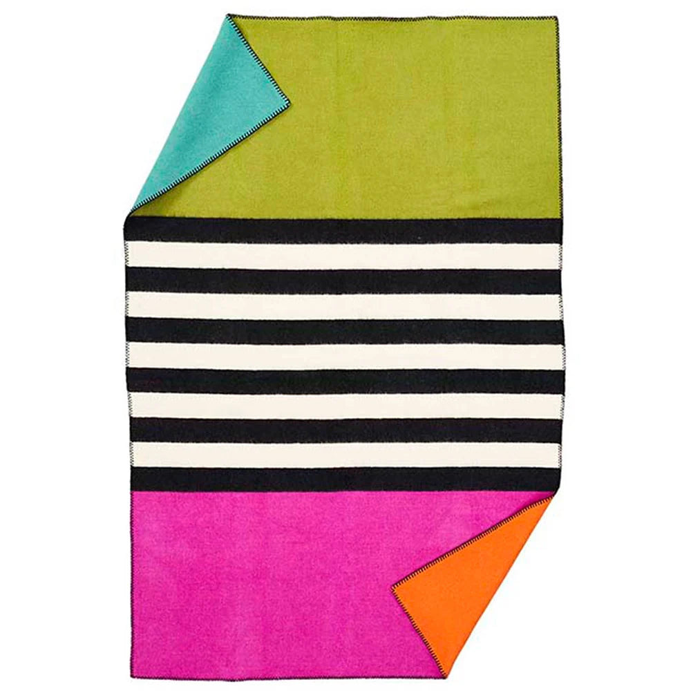 The Klippan Yllefabrik Blanket for Life Lambswool Throw, Thin Stripe, features a vibrant design with black and white horizontal stripes at the center, a green upper section, a pink lower section, and turquoise and orange corners turned up to reveal their solid backs—blending cozy lambswool comfort with bold style.