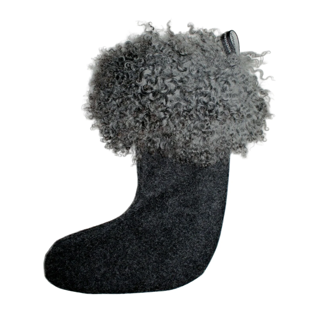 The Franni Sheepskin Christmas Stocking in black by Shepherd of Sweden features a smooth felt body and a thick, curly Gotland wool cuff with a hanging loop—a luxurious contrast for your holiday decor.