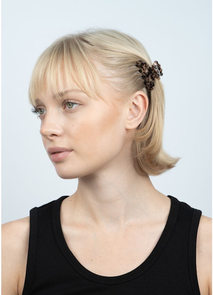 A person with dark brown, fine hair wearing a Sui Ava Helle Leo Mini Hair Claw Clip in Brown.