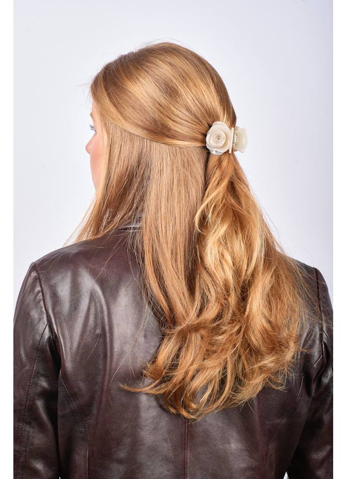 A Rosie Pastel Mini Hair Claw Clip in Cream Glitter Pink holding back a section of light brown hair.