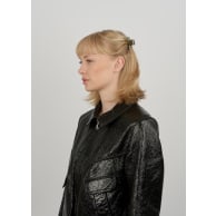 A small green and brown Lea Army Mini Hair Claw Clip by Sui Ava securing a section of hair at the back of a woman’s head.