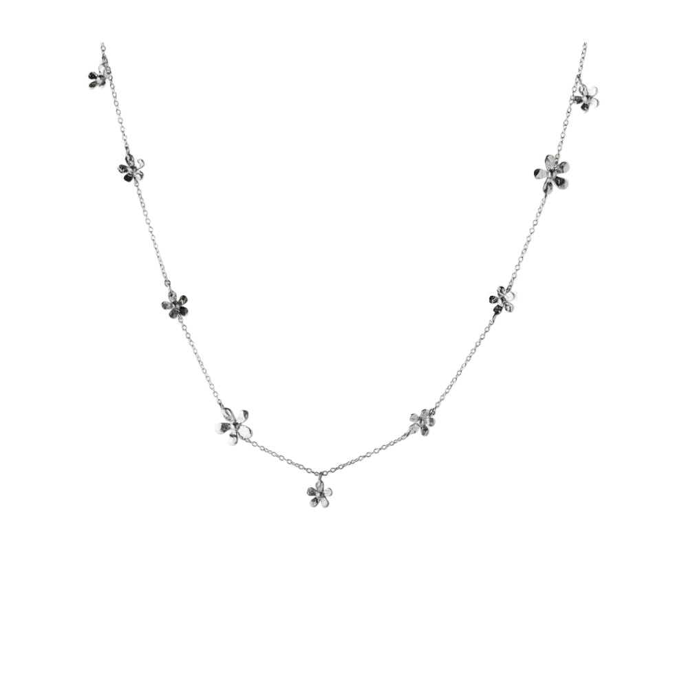 The Pernille Corydon Wild Poppy Necklace in Silver features silk-brushed, flower-shaped charms on a fine chain, shown on a white background—ideal for summer accessorizing.