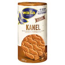 A cylindrical package of Cafe Wasa Kanel – Cinnamon Crispbread 330g with an image of crispbread and cinnamon sticks, Swedish text, a blue and gold logo, and labeled vegan friendly.